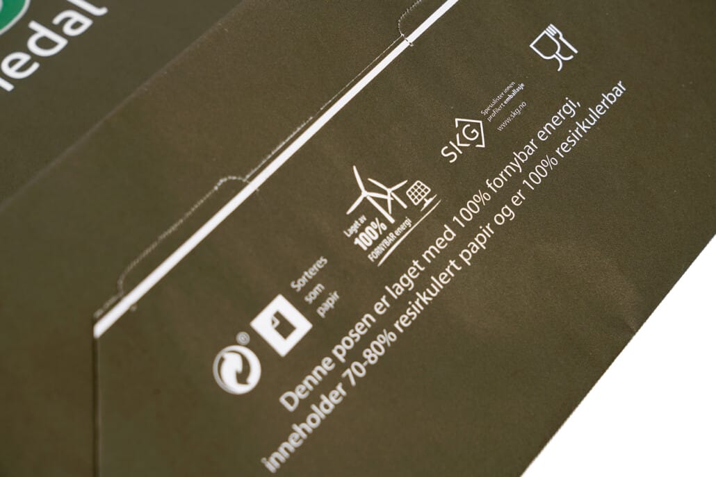 Miljømerking i bunnen av en papirpose med trykk | SKG - Spesialister innen profilert emballasje