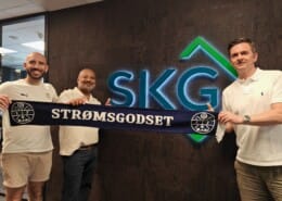 Selim Emeci fra Strømsgodset sammen med Amit Garg – gründer og daglig leder i SKG Emballasje, og Aleksander Engeset – salgs- og markedsleder i SKG, fotografert på SKG Emballasje AS sitt kontor i forbindelse med inngåelsen av partnerskap i Bronseklubben | SKG - Spesialister innen profilert emballasje